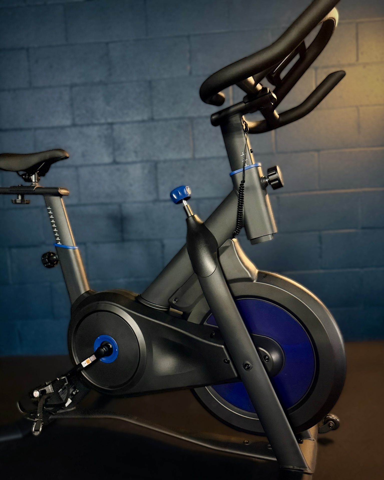 Indoor cycle with a blue flywheel in Revolve's cycle room